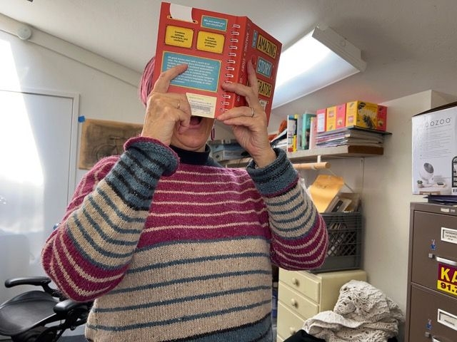 Laura McCamy with a book and hand-knitted sweater