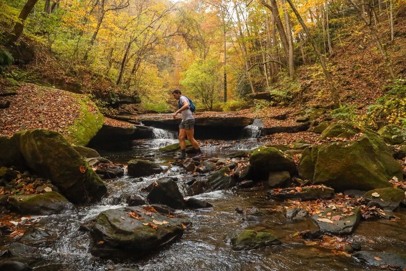 Tim Gorichanaz running across a creek