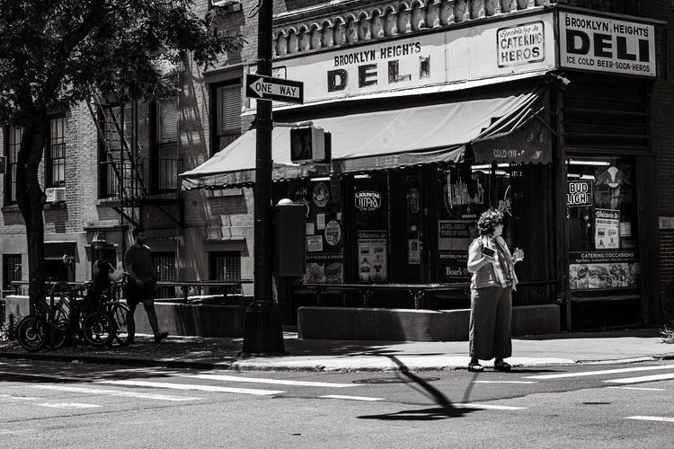 Tomas Jonsson's black-and-white street photo of a street corner with a deli