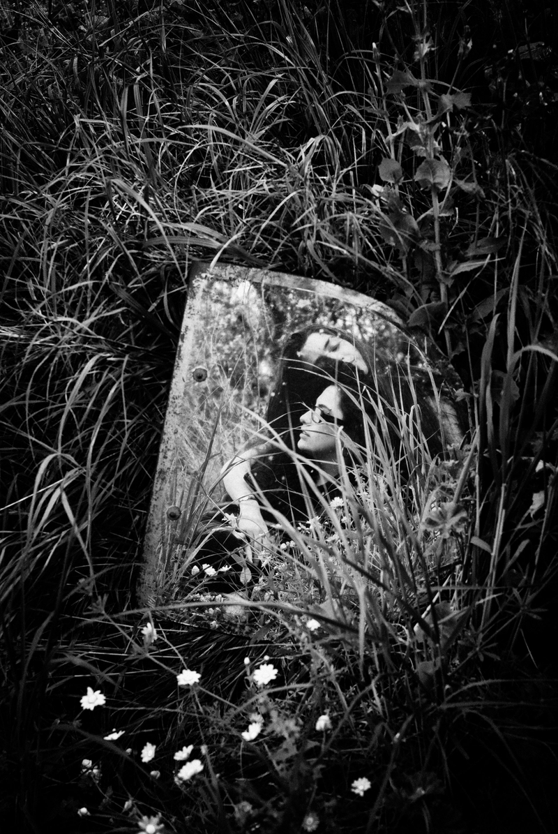 Ahmet Necati Uzer's black-and-white photo of an object in the grass; object has a photo of a woman on it