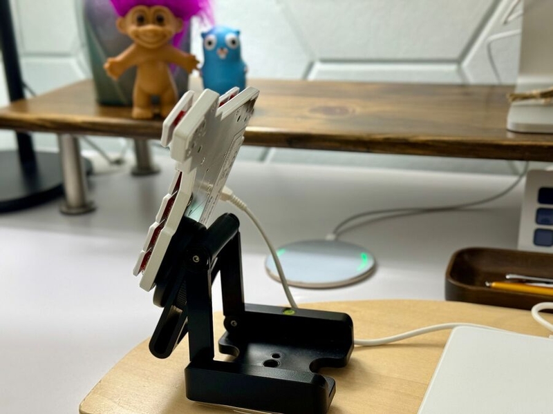 alt="Half of a split keyboard magnetically attached to a tripod mount. The keyboard is steeply tented and nearly in profile, with the mount attached far down the left edge."